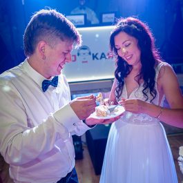 Smakowanie tortu weselnego przez młodych małżonków.