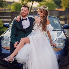 Zdjęcie plenerowe Młodej Pary w dniu ślubu przy samochodzie sportowym Porshe.